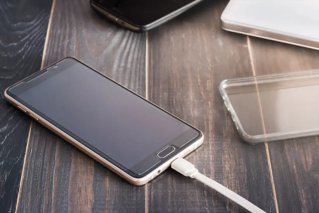 Smartphone en train de recharger sa batterie via un câble USB